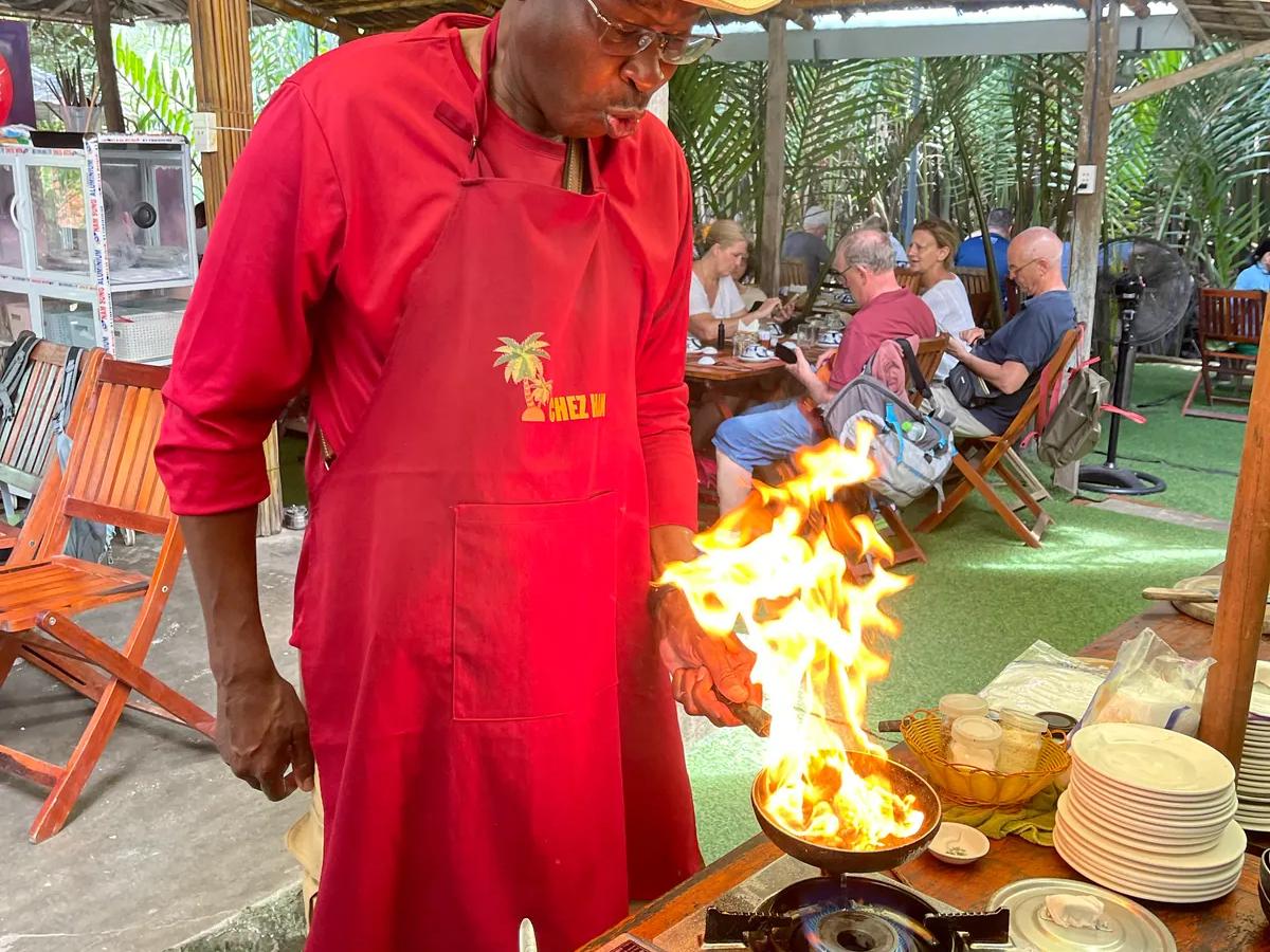 A guest cooking over an open flame at the village cooking class