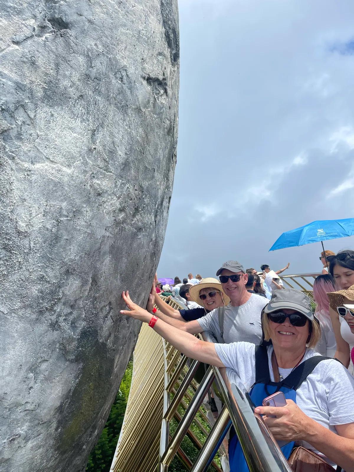 Guests on the Golden Bridge beside one of the giant stone hands