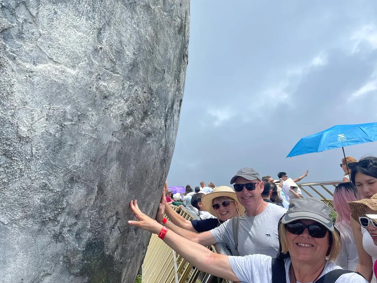 Guests on the Golden Bridge beside one of the giant stone hands