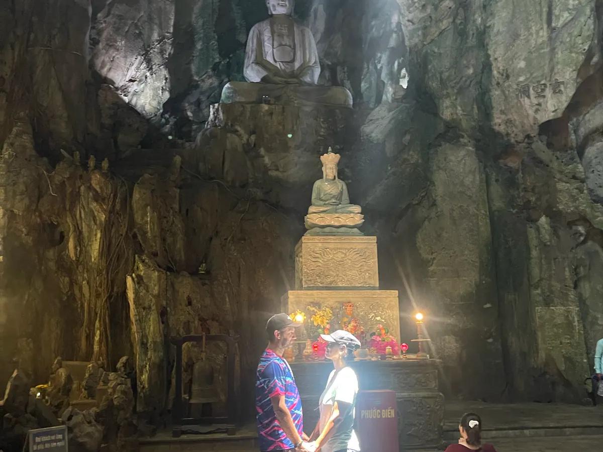 Guests standing in the shaft of light inside a Marble Mountains cave