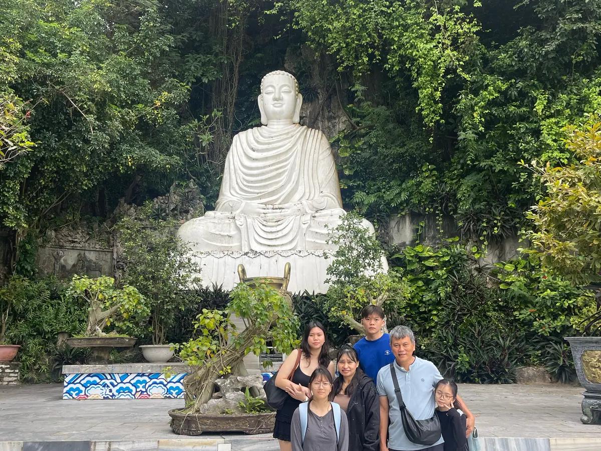 A family below the Lady Buddha statue on the Son Tra Peninsula