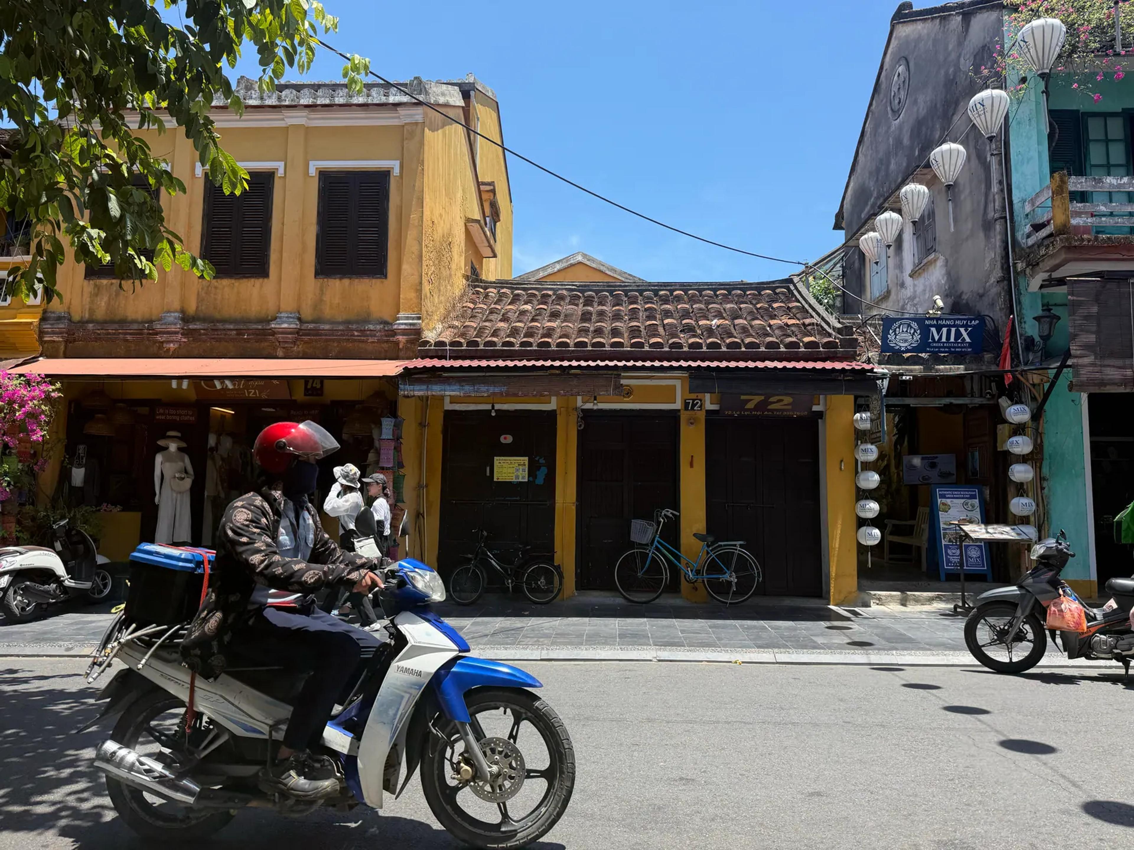 Yellow merchant houses and lanterns on a quiet Hoi An street