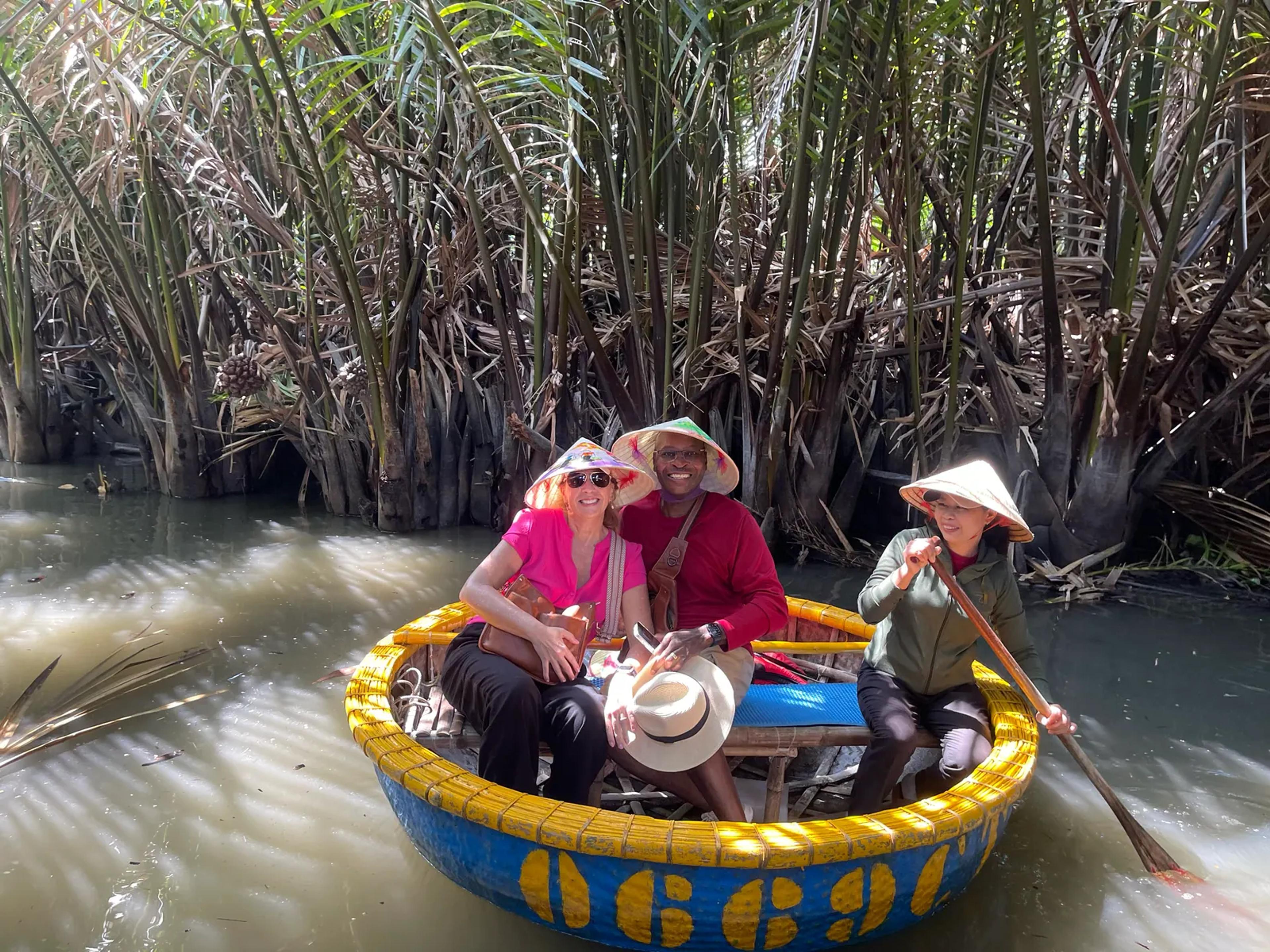 Guests paddling a basket boat through the nipa palms at Cam Thanh
