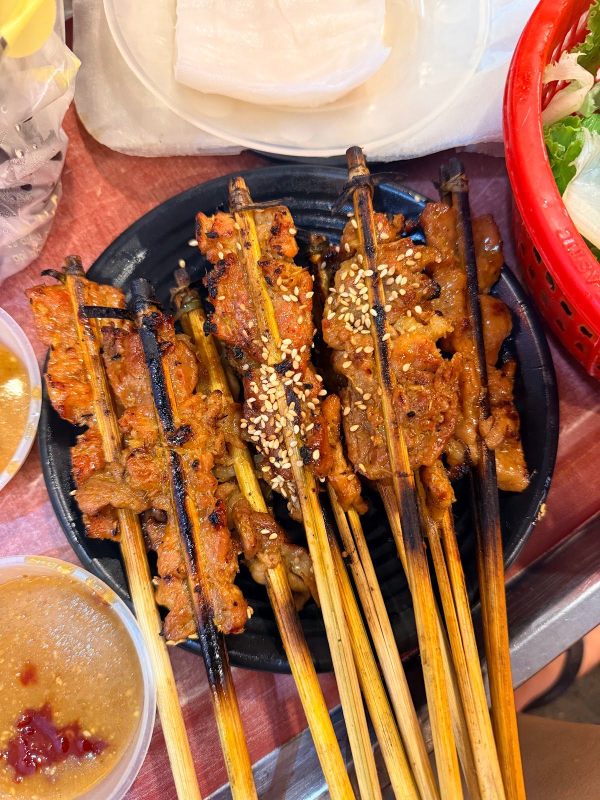 Grilled pork skewers with sesame, rice paper and dipping sauce at Thịt Nướng Cô Lợi in Hoi An