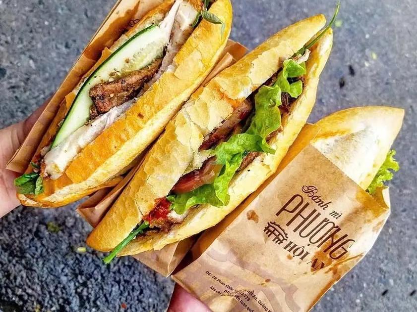 Two banh mi from Banh Mi Phuong in Hoi An, half out of the shop's paper bag