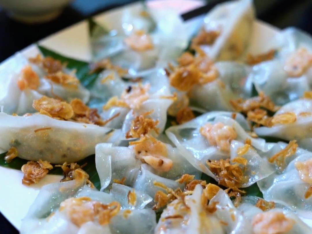 A plate of white rose dumplings topped with fried shallots at White Rose Restaurant in Hoi An