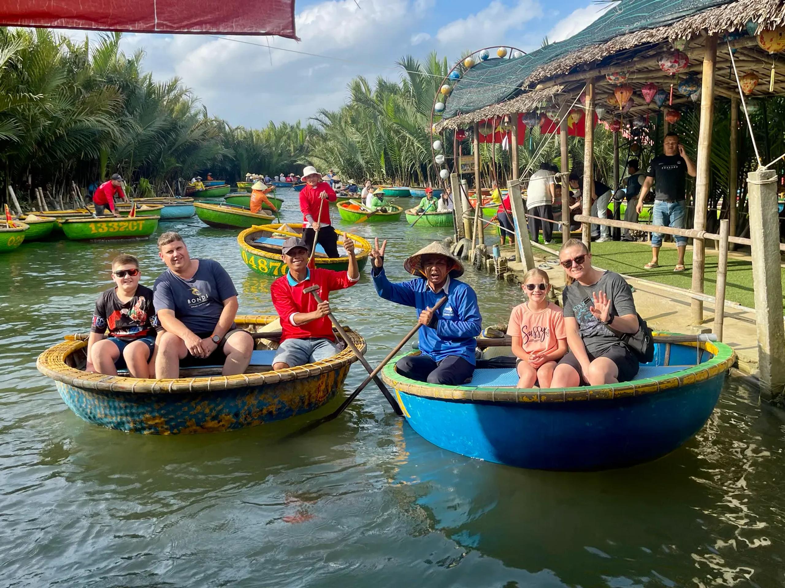 Round bamboo basket boats carrying visitors through the water coconut palms outside Hoi An