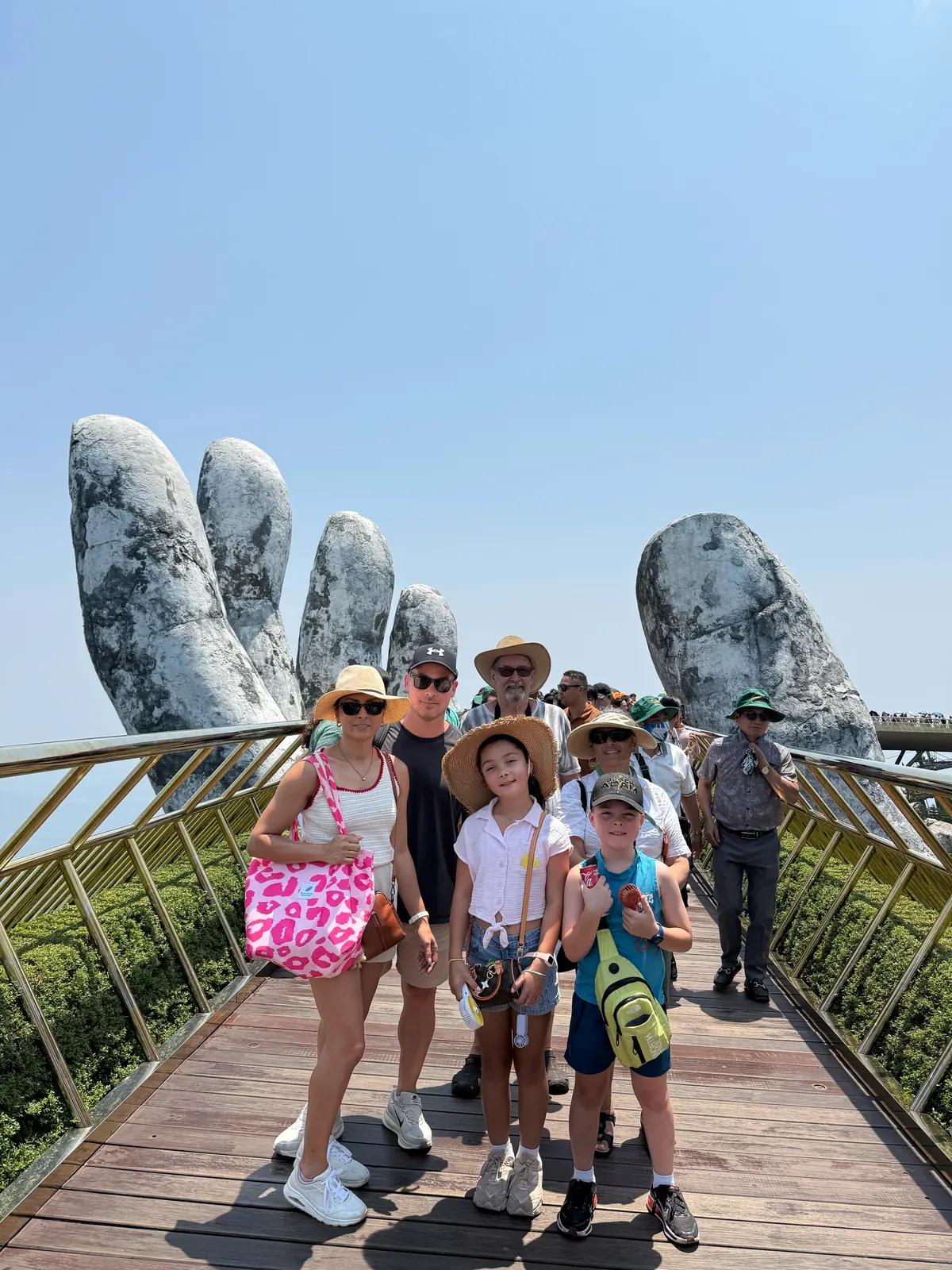 A family walking the Golden Bridge above the forest