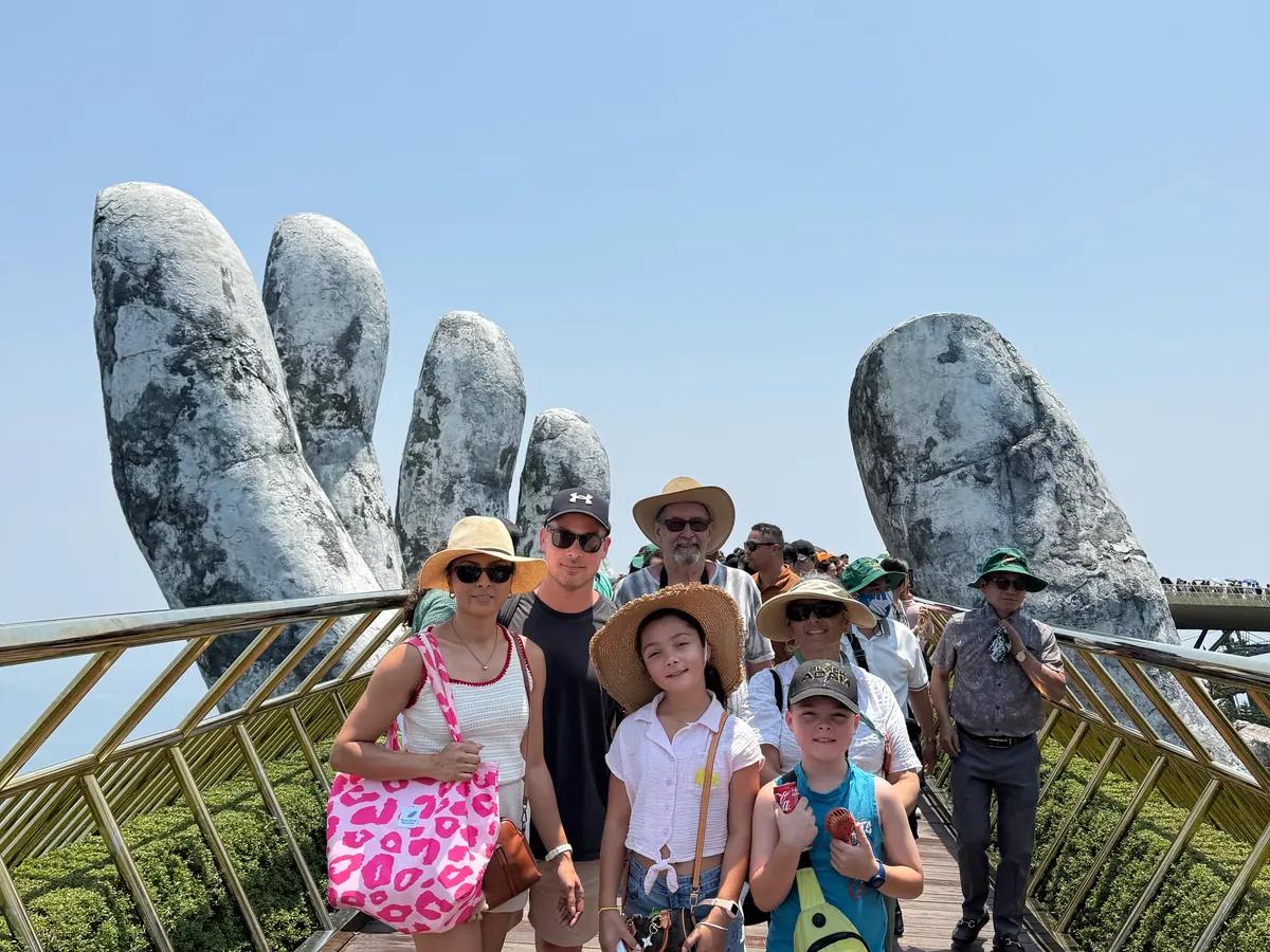 A family walking the Golden Bridge above the forest
