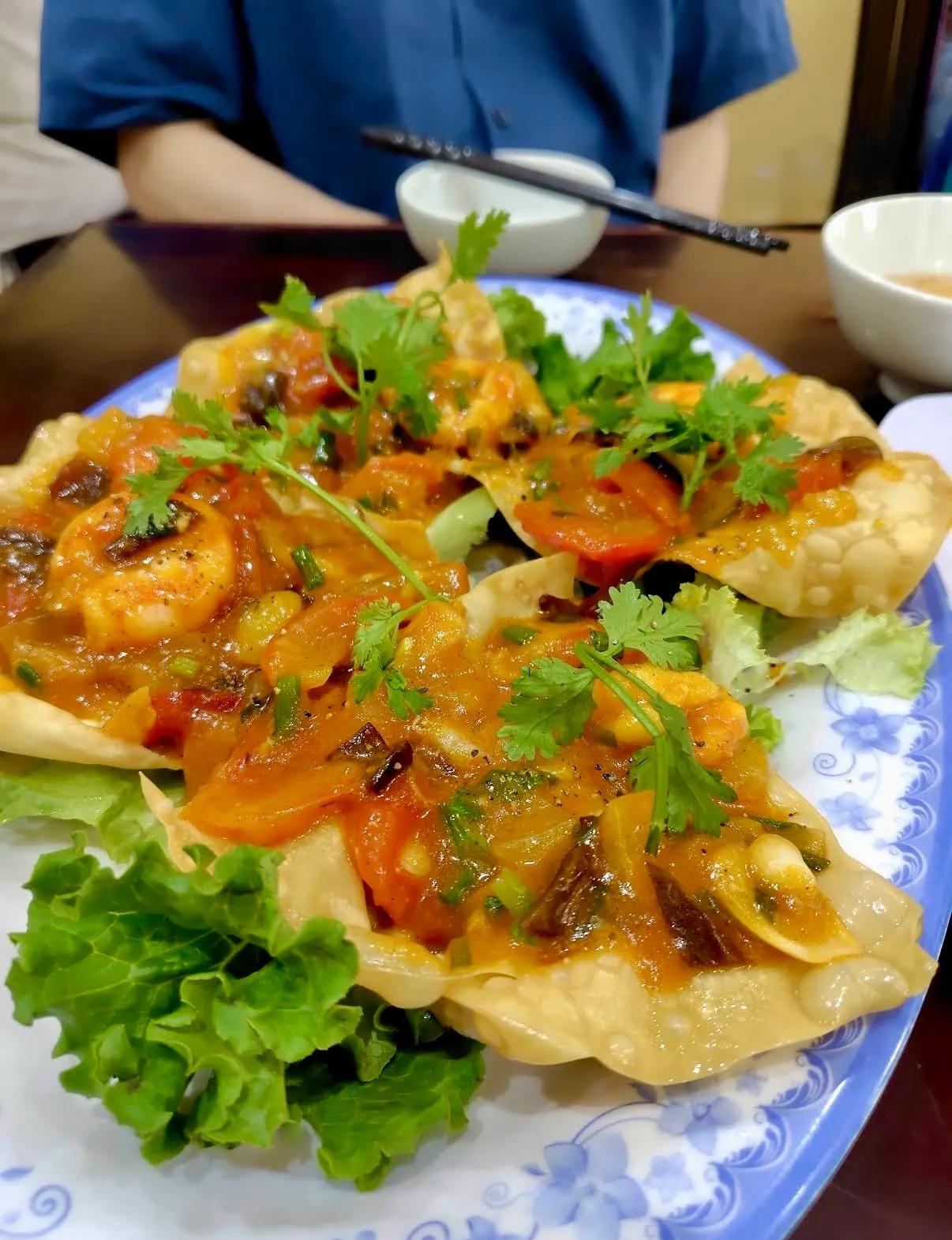 Crispy fried wontons topped with shrimp, tomato and fresh herbs, a Hoi An specialty