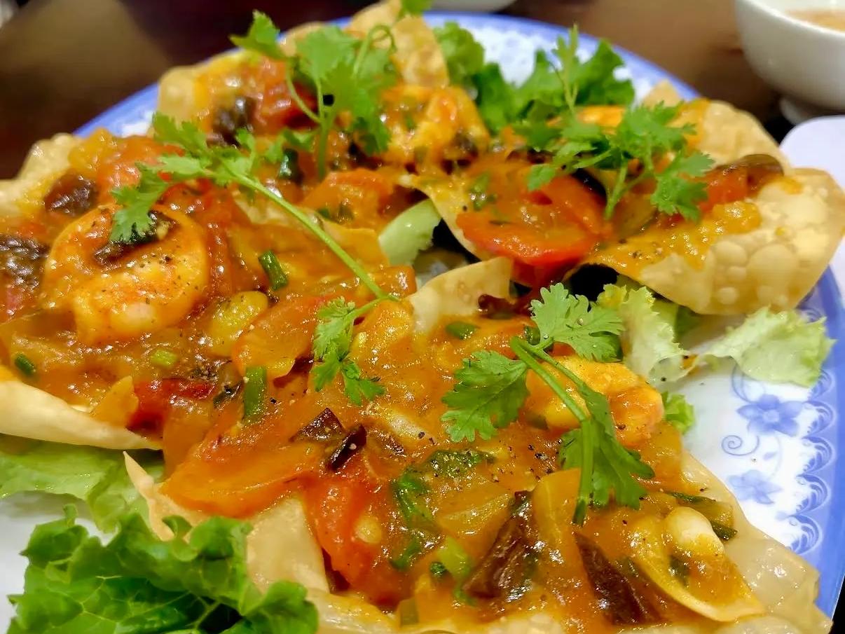 Crispy fried wontons topped with shrimp, tomato and fresh herbs, a Hoi An specialty