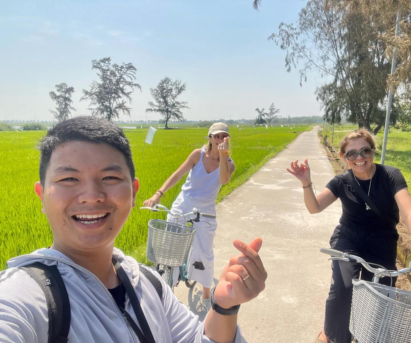 Tom and two guests on bicycles between the rice paddies near Hoi An