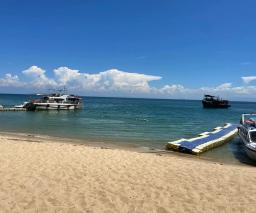 Speedboats moored off a sandy beach on Cham Island, beside a floating jetty in turquoise water