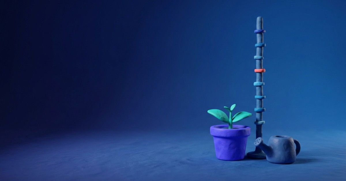 Clay seedling beside a measuring stick with growth markers and a watering can: measurement-based care
