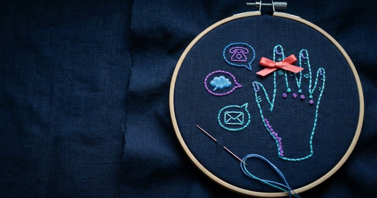 Embroidered hand with a reminder bow on one finger beside SMS, chat and email icons: appointment reminders