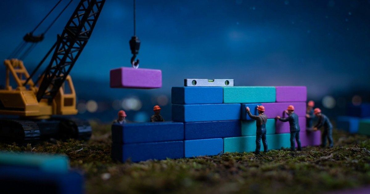 Miniature builders laying a level wall of colour-coded blocks: structured notes reducing compliance risk