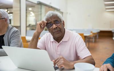 man sat at laptop looking worried