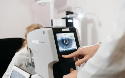 eye examination machine wshowing image of an eye with doctors hand controlling it