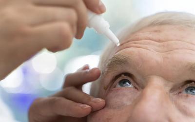 eye drops being poured into a mans eye