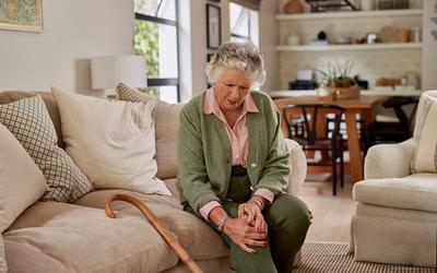 woman sitting on the sofa with knee pain