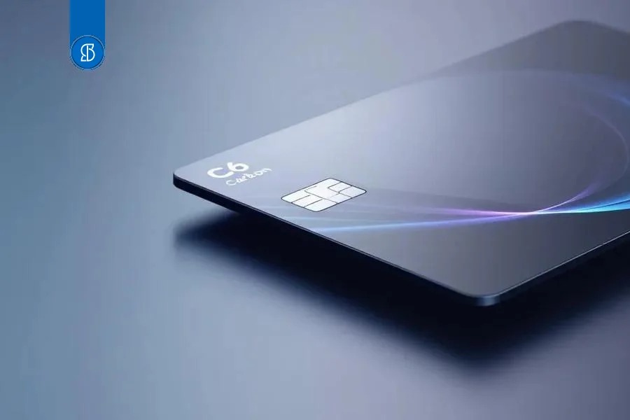 Cartão escuro C6 Carbon inclinado, com reflexo iridescente na superfície