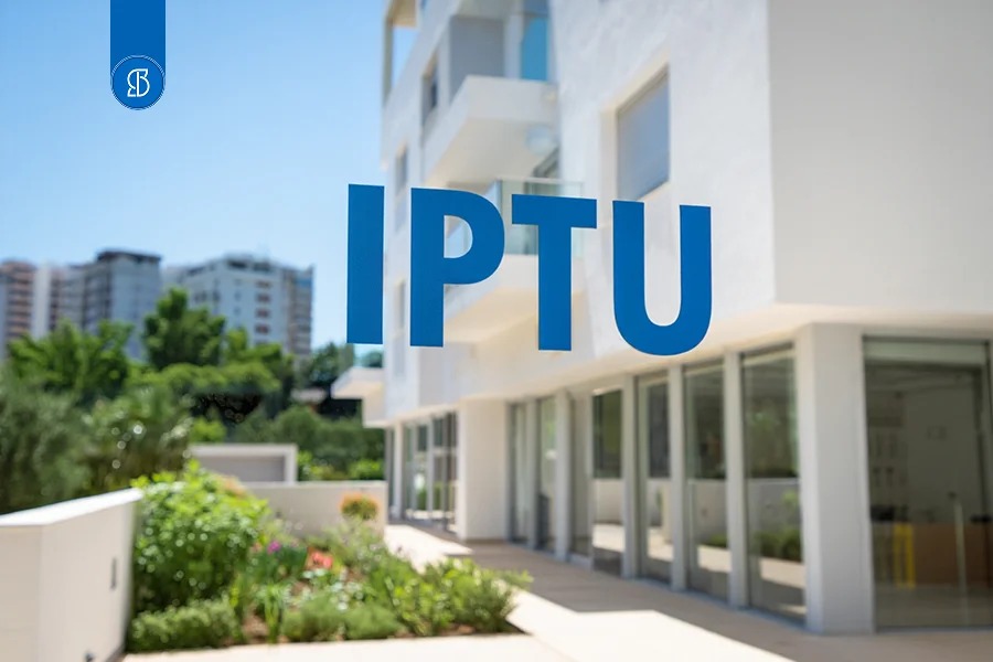 Fachada de prédio residencial branco com jardim, e a sigla IPTU em azul