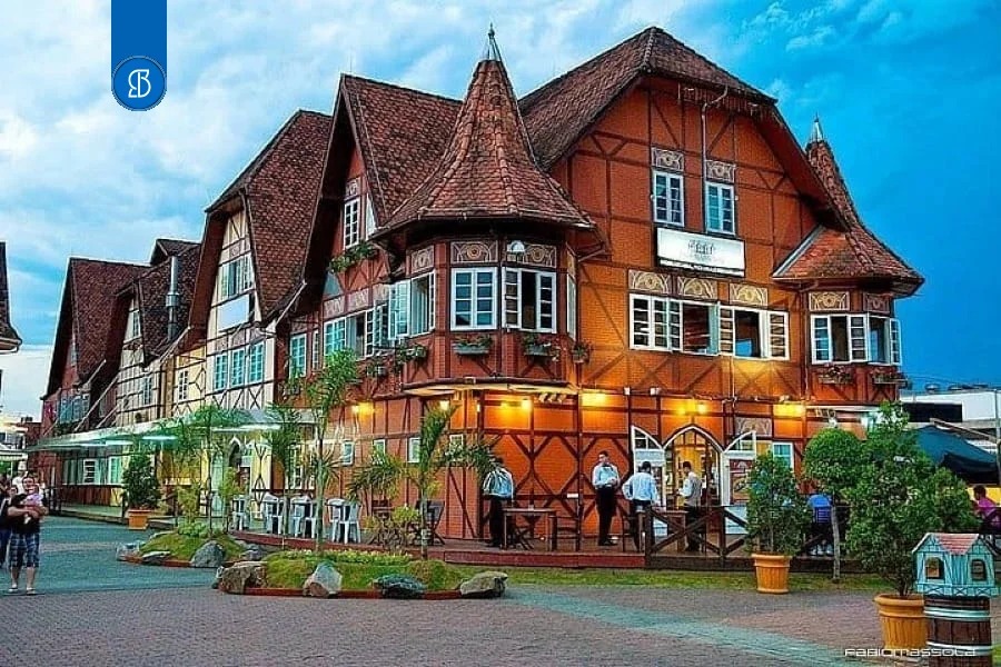Casarão de arquitetura enxaimel em Blumenau, com pessoas em frente ao entardecer
