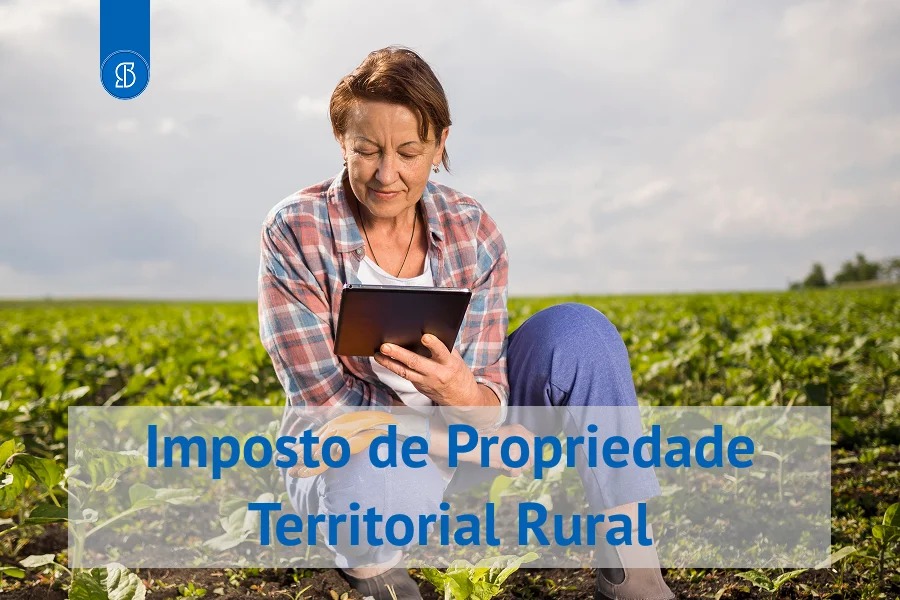 Produtora rural agachada em uma lavoura consultando um tablet