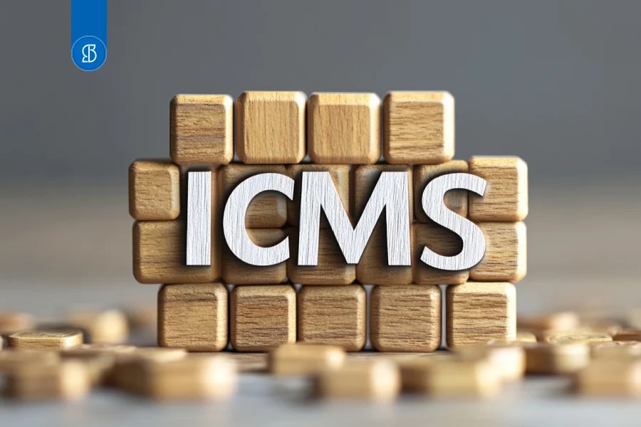 Letras brancas formando ICMS sobre cubos de madeira empilhados