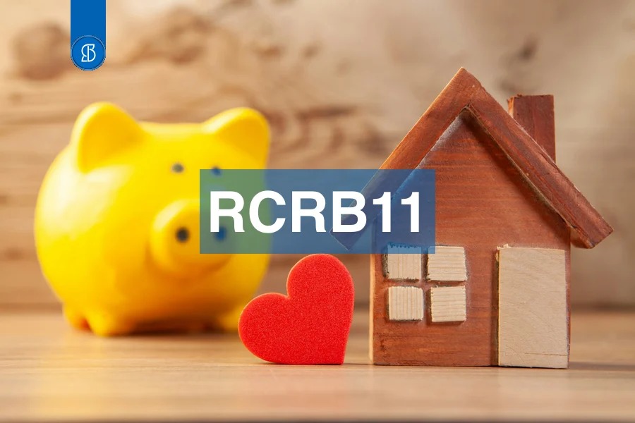 Cofre de porquinho amarelo ao lado de casa de madeira e coração vermelho, com o código RCRB11 em faixa azul ao centro