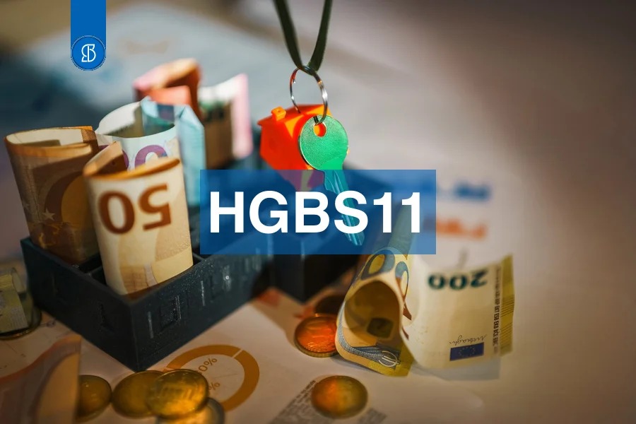 Notas de euro enroladas dentro de maquetes de casas, com uma chave verde, com o código HGBS11 em faixa azul ao centro