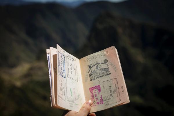 An image of someone holding a passport with a lot of traveler stamps