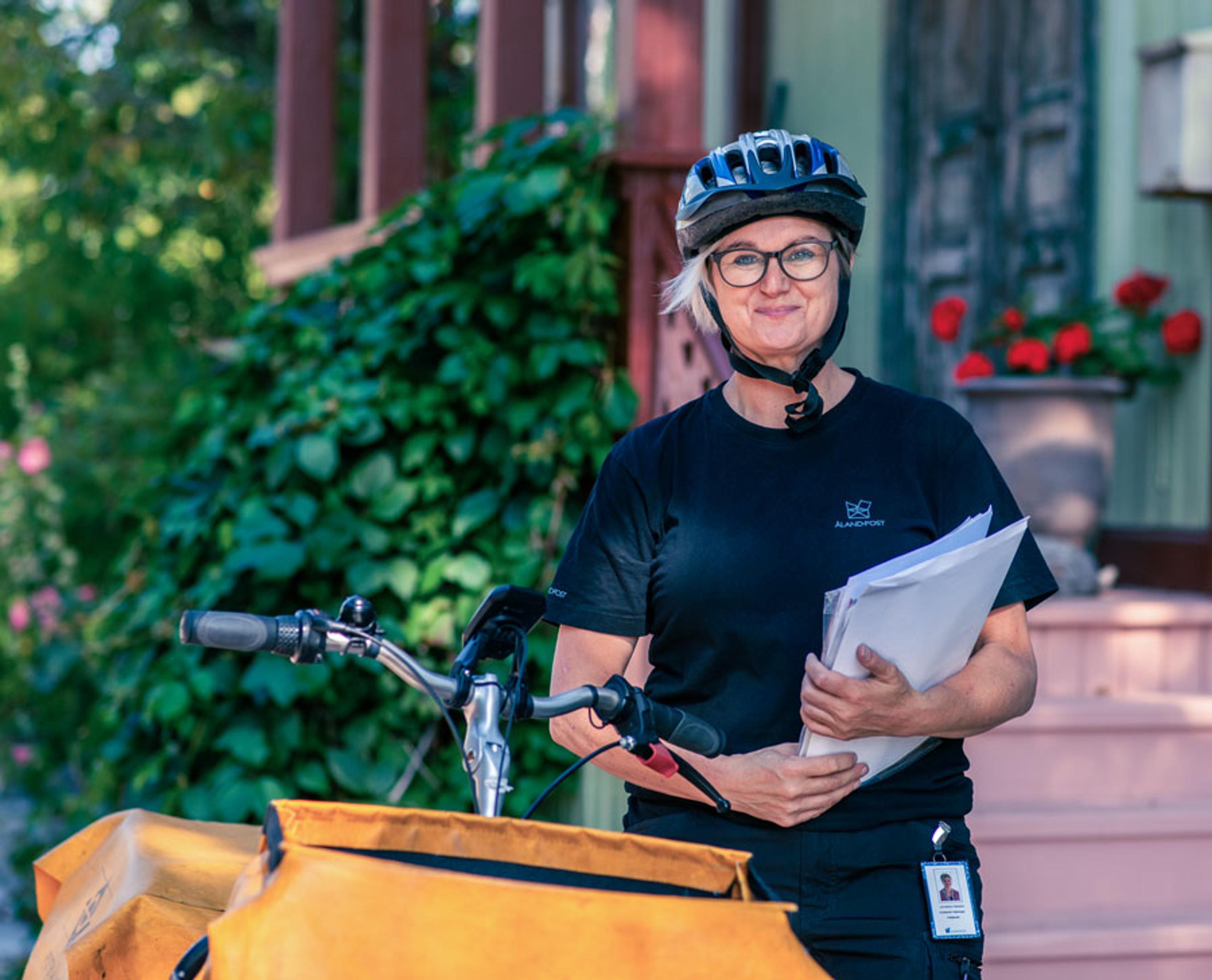 postutdelare med cykelhjälm vid cykel