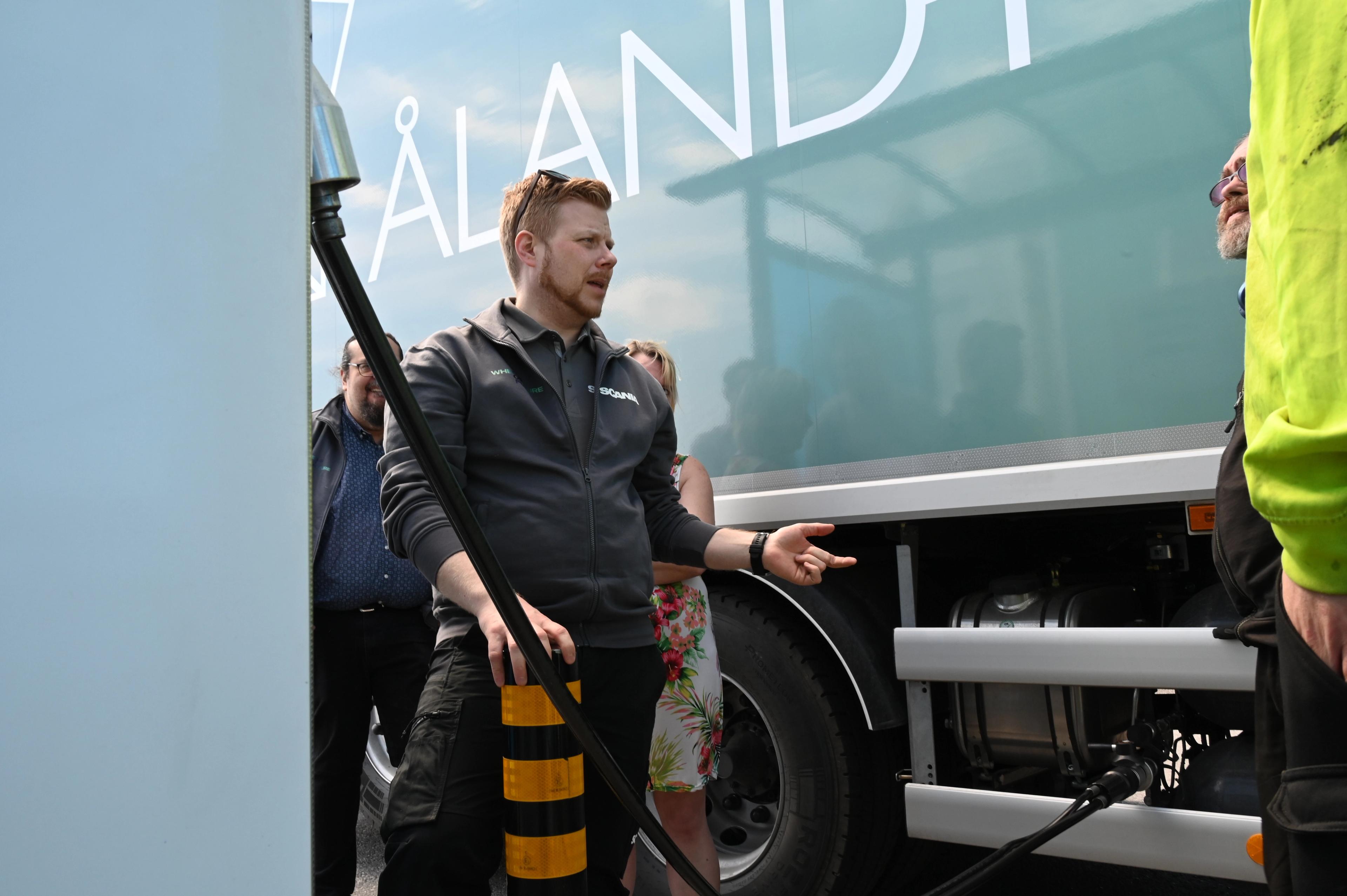 Åland Post gaslastbil. Scanias representant visar hur det fungerar.