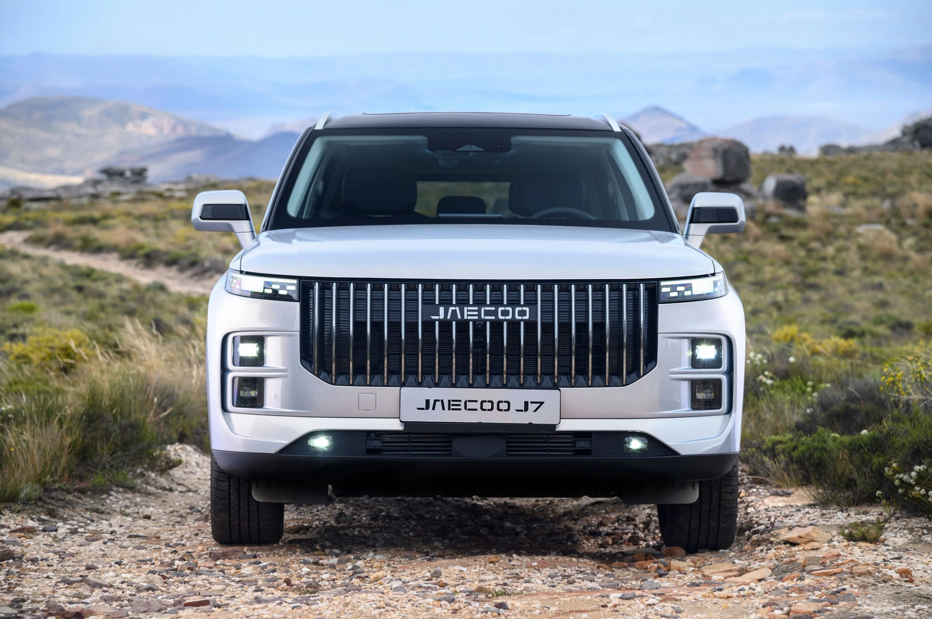 Front view of a white JAECOO J7 SUV on a mountain trail