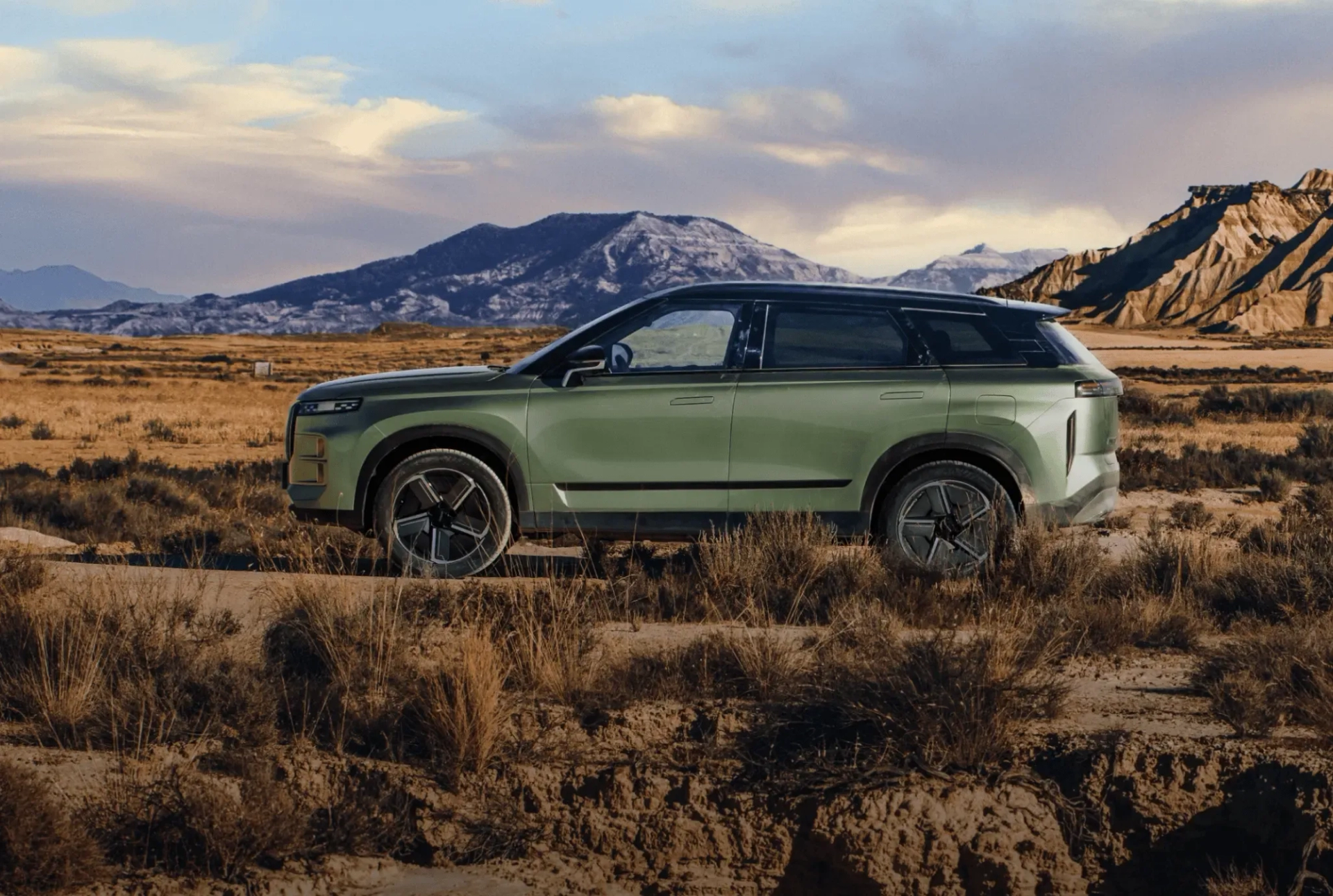 A green JAECOO 8 on an arid mountain road