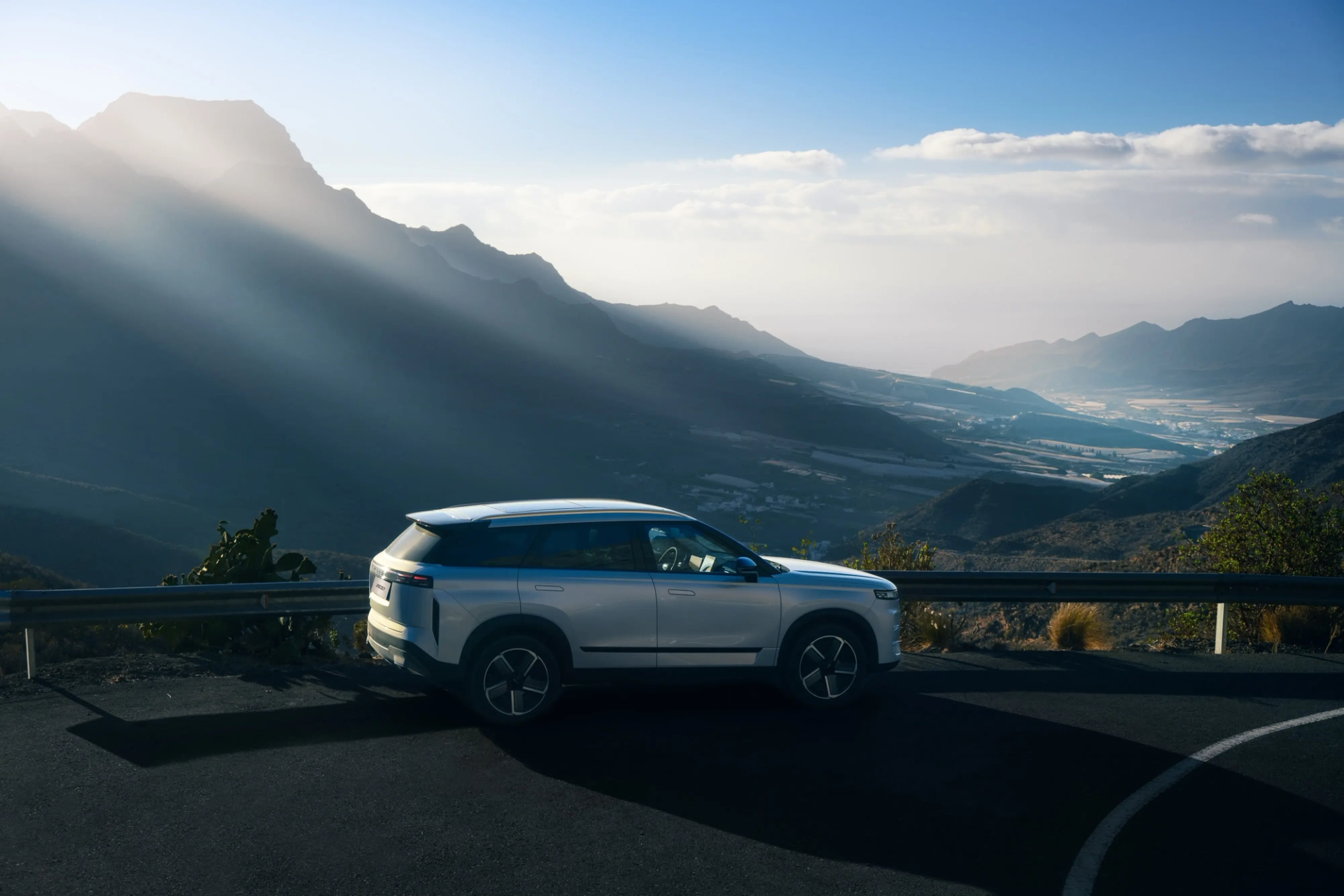 A white JAECOO 7 parked on a mountain pass overlooking a valley