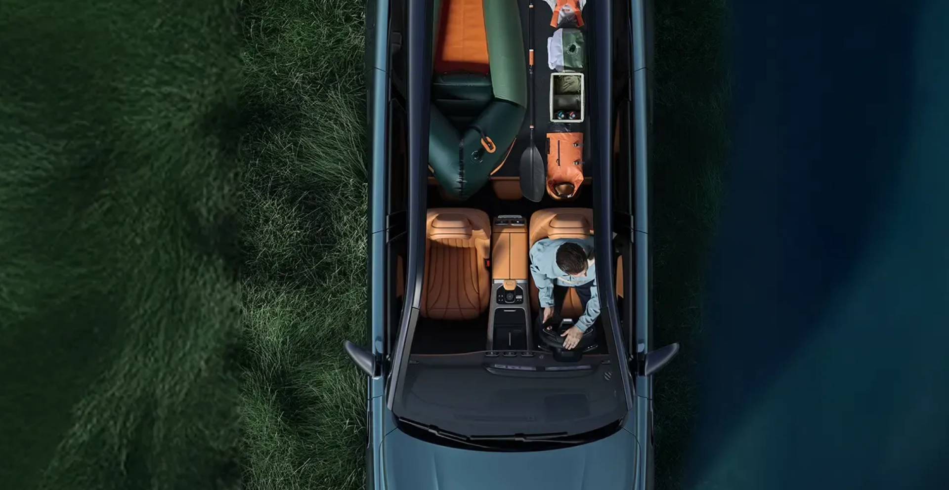 Overhead view of a JAECOO SUV parked on grass, its interior loaded with outdoor and camping gear