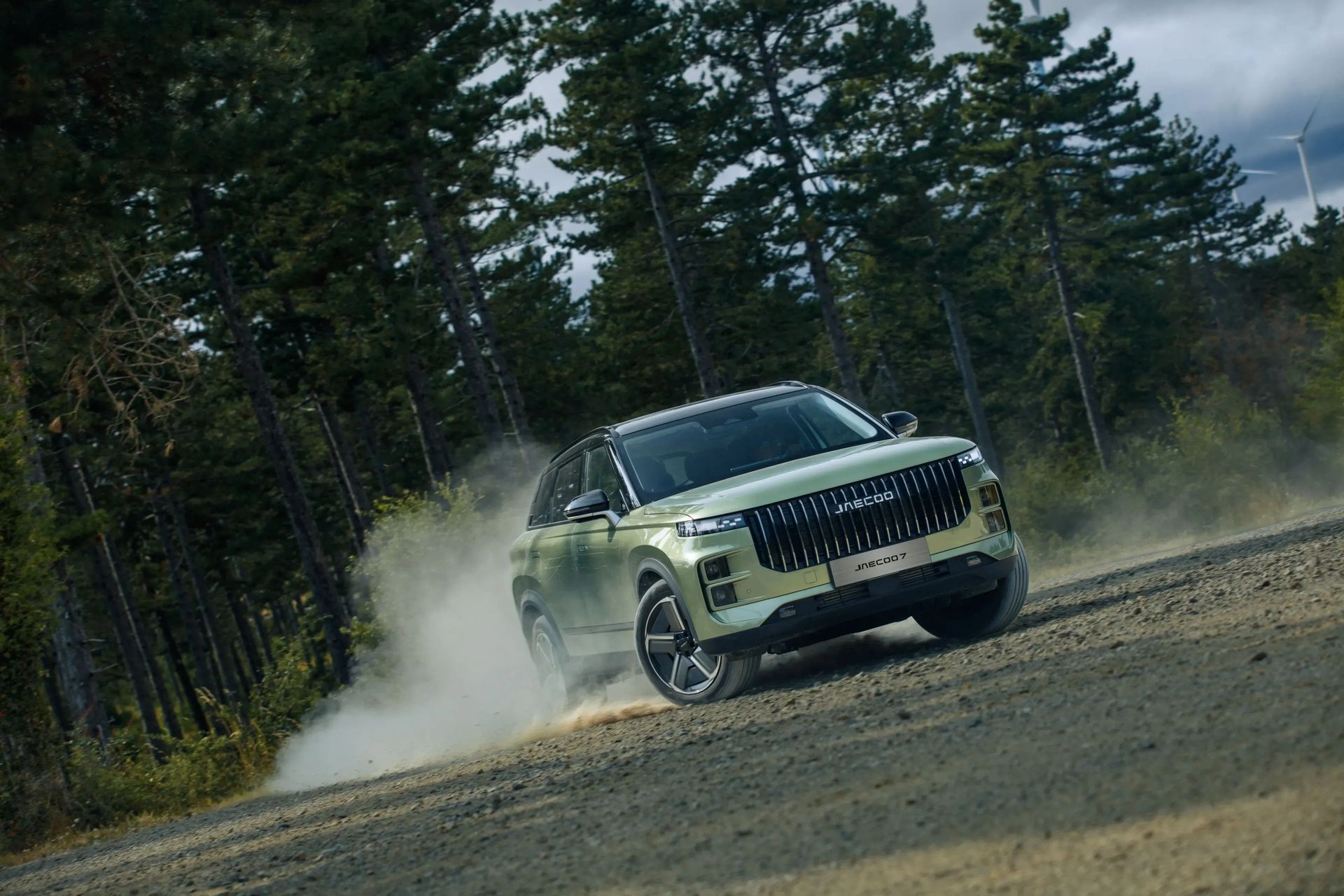 A green JAECOO 7 driving on a forest trail