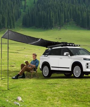 JAECOO fitted with the Adventure Pack roof rack and side awning, pitched on grass