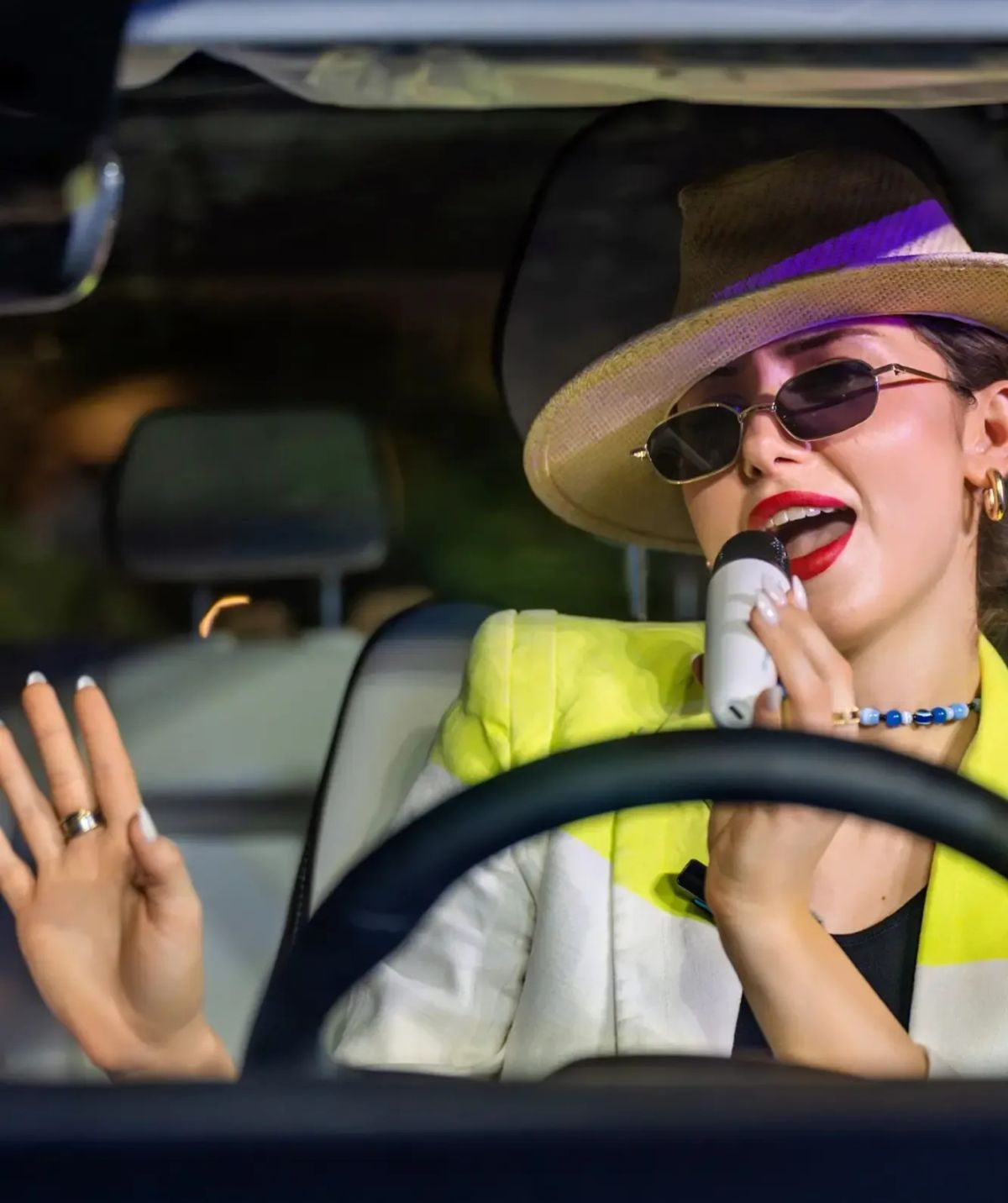 Driver singing along using the JAECOO karaoke microphone in the car