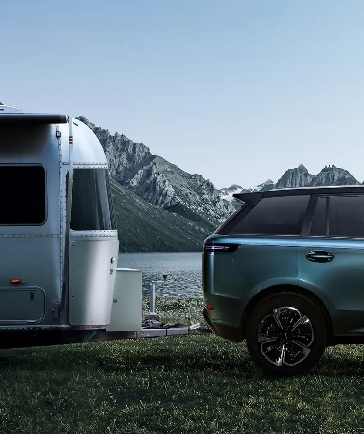 JAECOO 5 towing a caravan beside a mountain lake