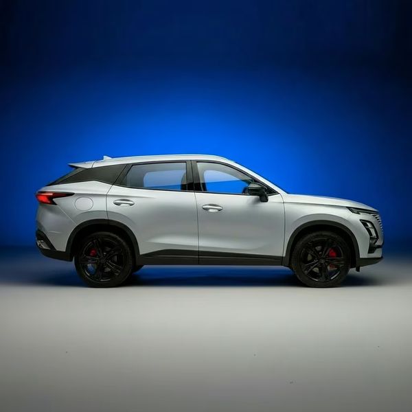 OMODA 5 in white, side profile against a blue studio backdrop