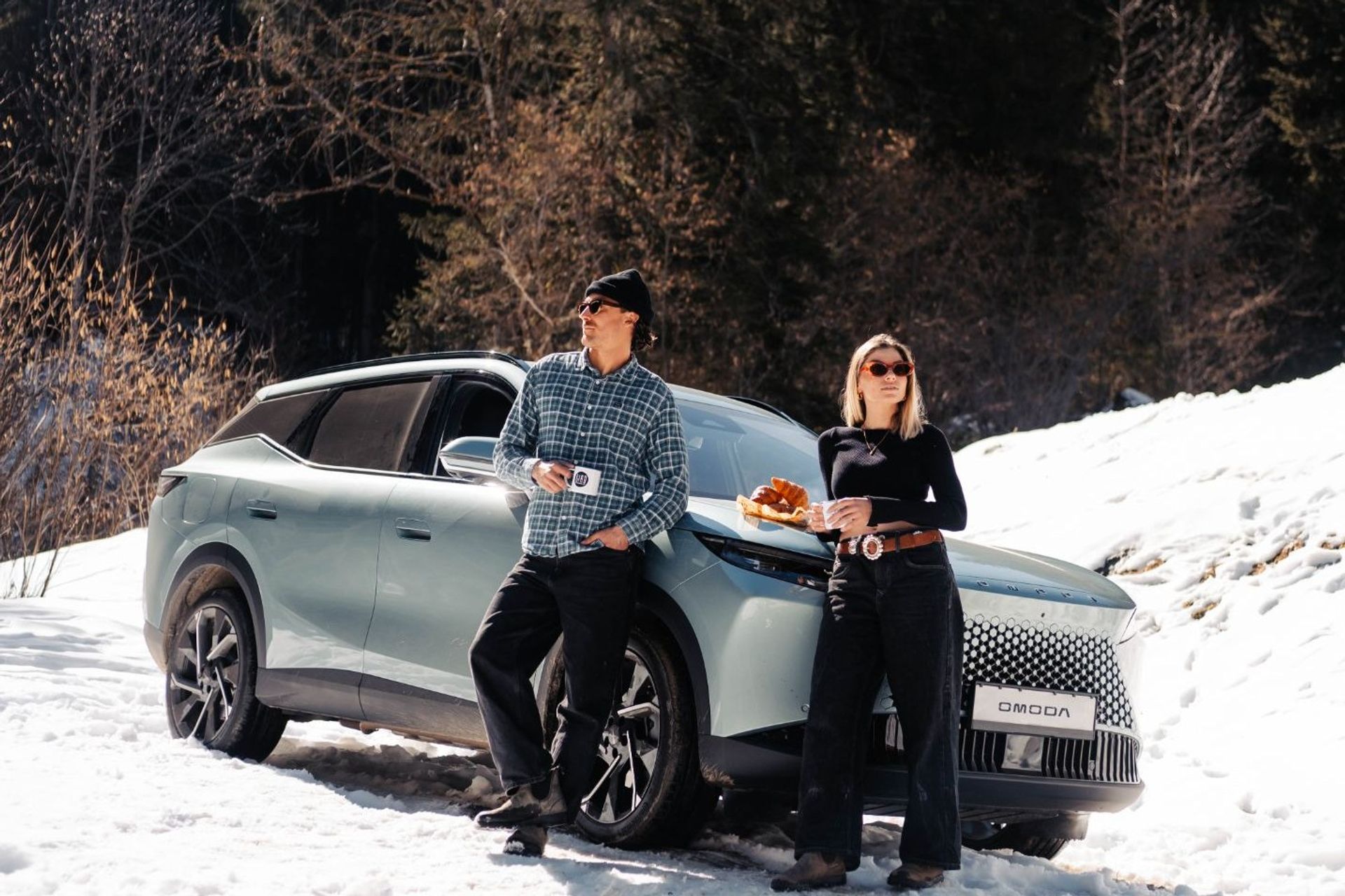 OMODA 5 parked in the snow with two people having coffee