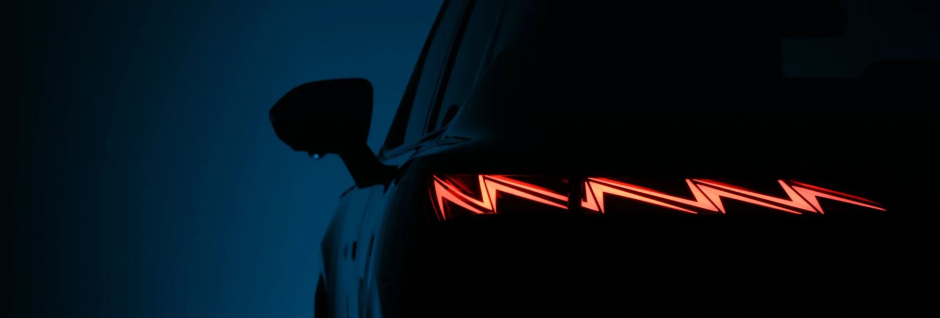 Close-up of an OMODA SUV's illuminated rear tail light at night