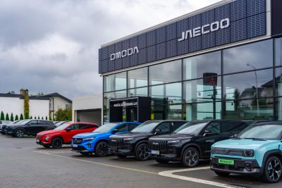 OMODA and JAECOO dealership showroom front with cars parked outside