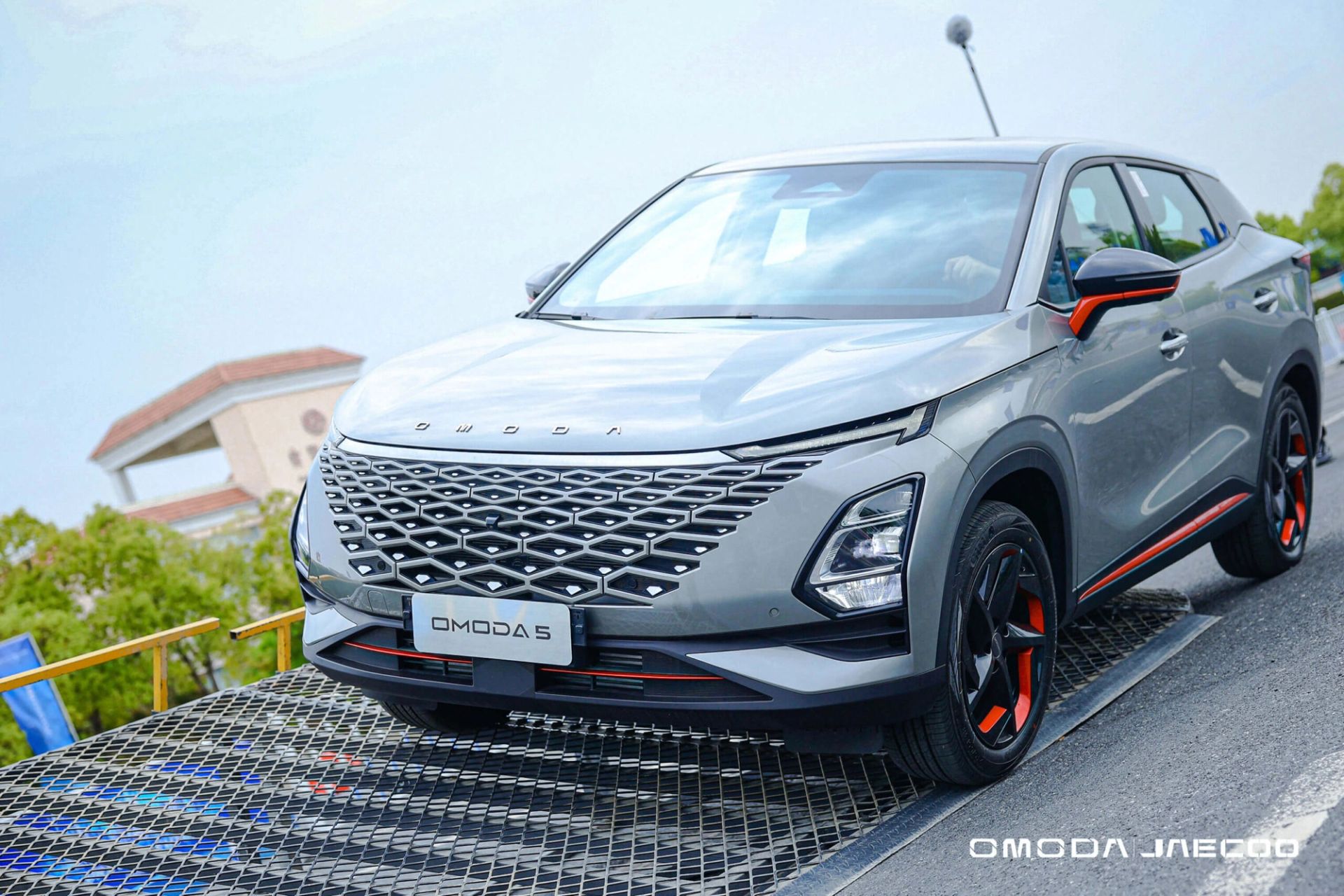 OMODA 5 in grey with orange trim parked on an event ramp