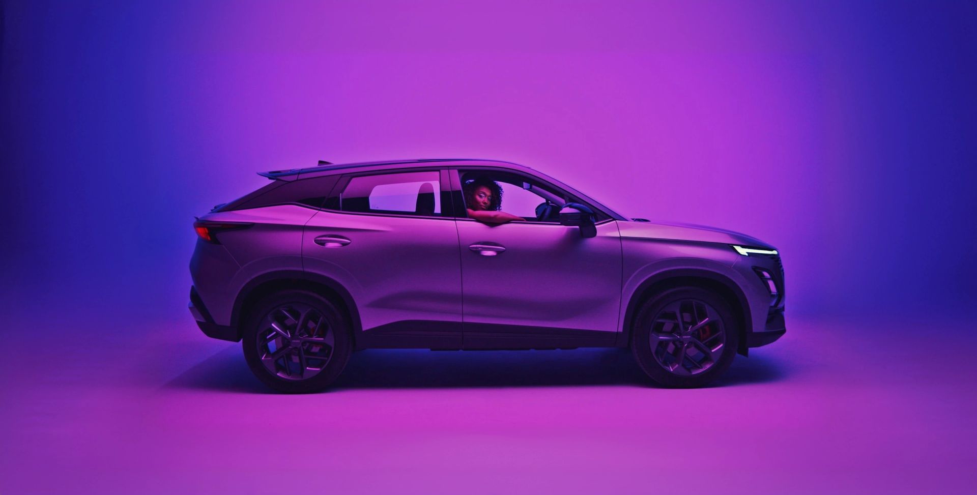 OMODA SUV side profile lit on a purple background