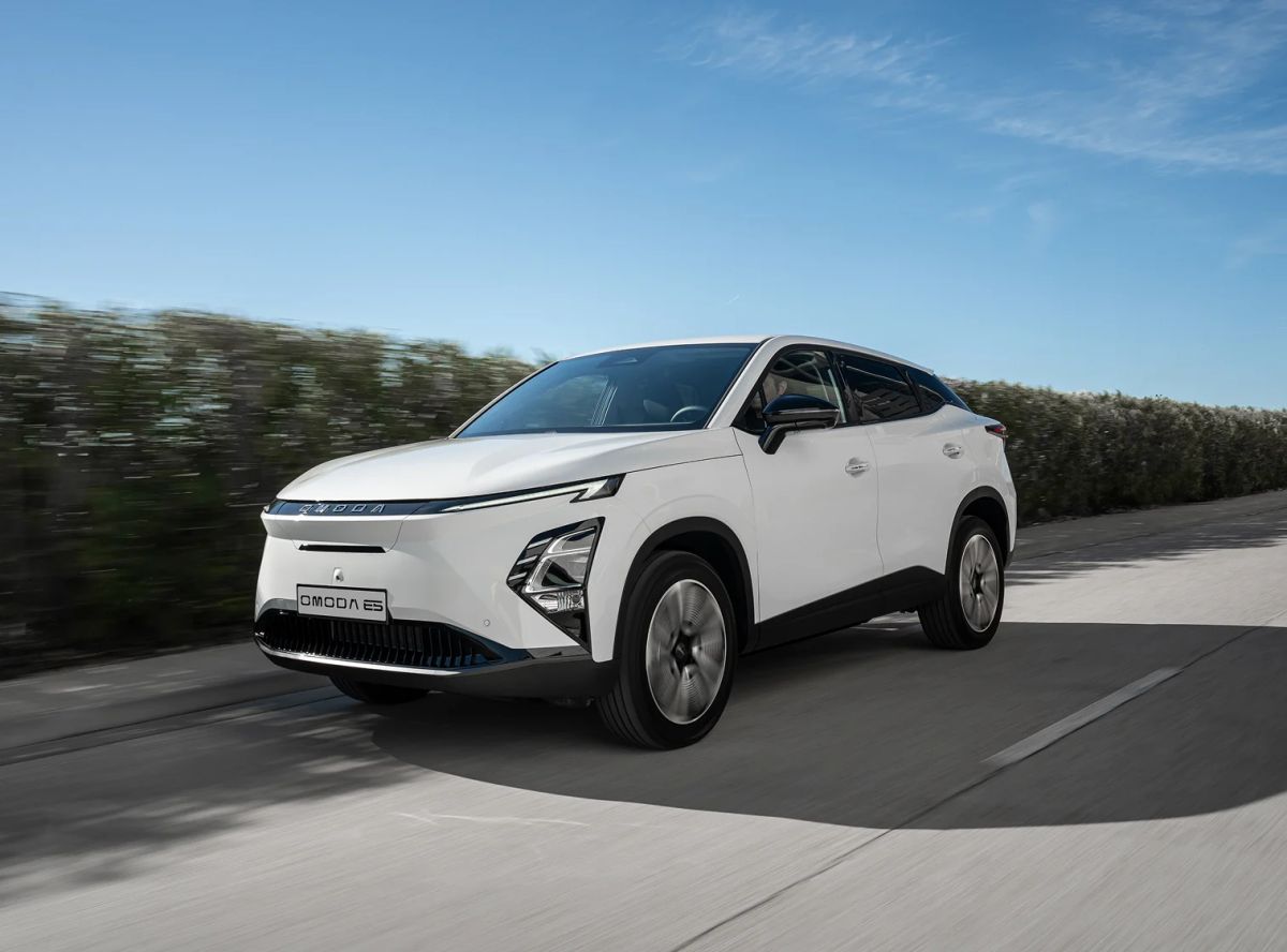 A green OMODA electric SUV in a studio lighting setup