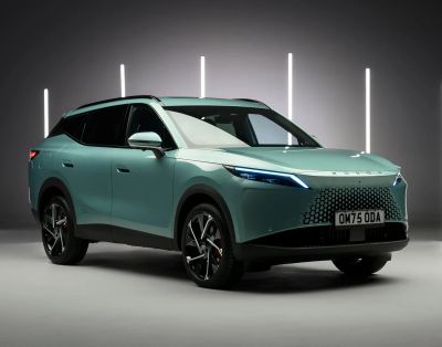 A green OMODA electric SUV in a studio lighting setup